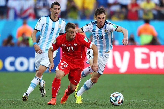 SAO PAULO, BRAZIL - JULY 01:  Xherdan Shaqiri of Switzerland is challenged by Angel di Maria (L) and Jose Maria Basanta of Argentina  during the 2014 FIFA World Cup Brazil Round of 16 match between Argentina and Switzerland at Arena de Sao Paulo on July 1, 2014 in Sao Paulo, Brazil.  (Photo by Jamie Squire/Getty Images)
