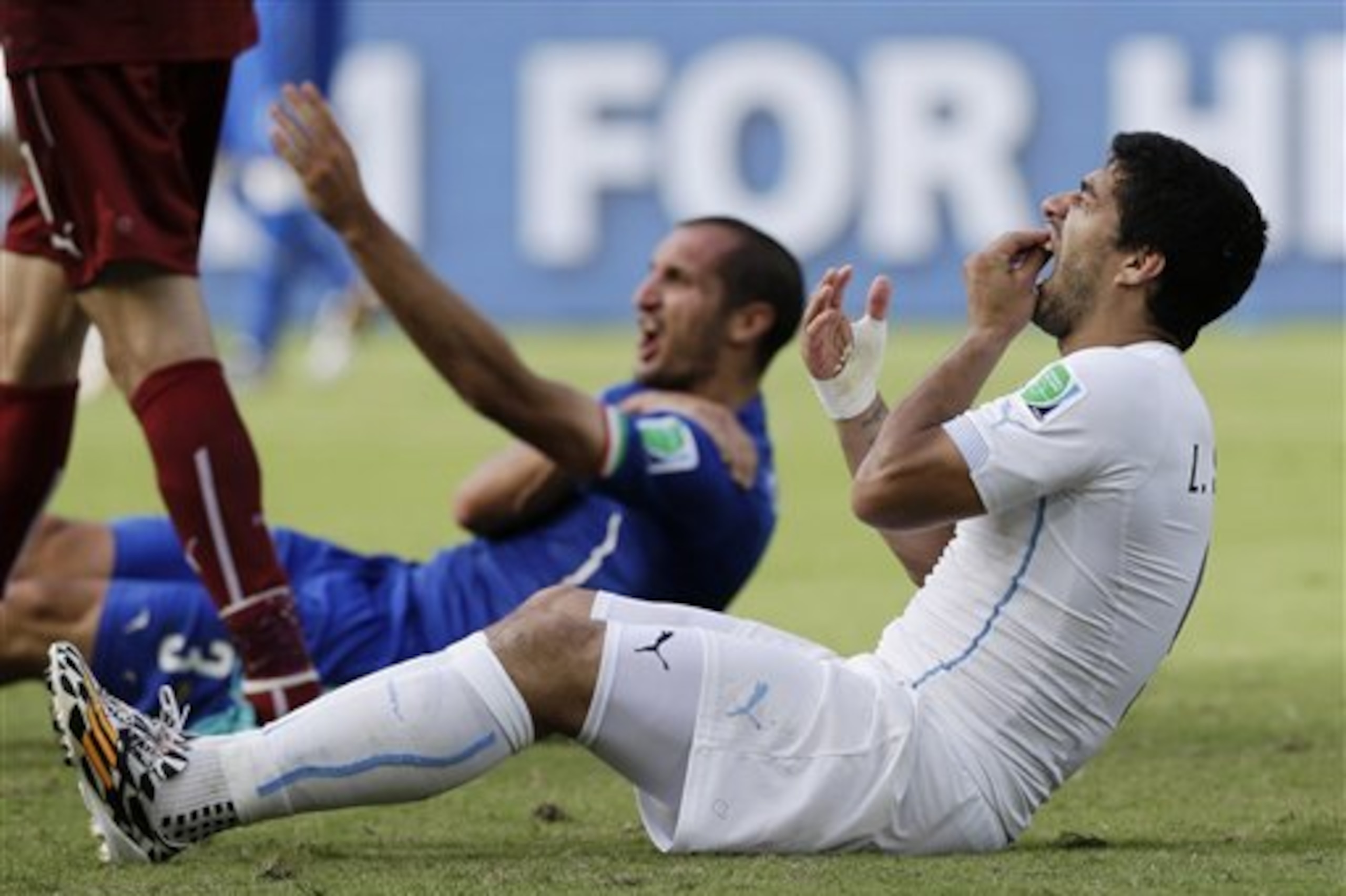 FILE - In this June 24, 2014 file photo, Uruguay's Luis Suarez holds his teeth after biting Italy's Giorgio Chiellini's shoulder during the group D World Cup soccer match between Italy and Uruguay in Natal, Brazil. Sinking teeth into the shoulder of Giorgio Chiellini in a group-stage game led to a four-month ban from all football for the Uruguay striker. (AP Photo/Ricardo Mazalan, File)