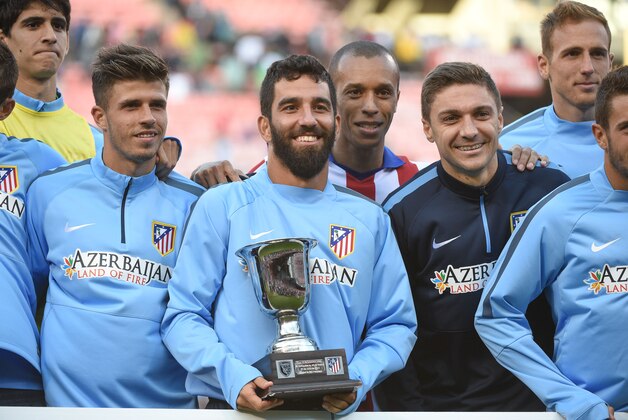 July 27, 2014; San Francisco, CA, USA; Atletico Madrid player Arda Turan (10) holds the winner's trophy with his team after the match against the San Jose Earthquakes at Candlestick Park. Atletico Madrid defeated the Earthquakes 4-3 in a shootout. Mandatory Credit: Kyle Terada-USA TODAY Sports