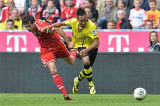Bayern's Javier Martinez of Spain, left, and Dortmund's Pierre-Emerick Aubameyang of Gabon challenge for the ball during the Bundesliga soccer match between FC Bayern Munich and Borussia Dortmund in Munich, Germany, on Saturday, April 12, 2014. (AP Photo/Kerstin Joensson)