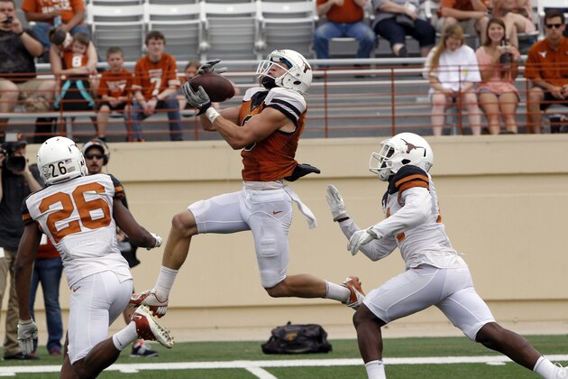 Texas receiver Jaxson Shipley, center, catches a touchdown pass against Adrian Colbert (26) and Chevoski Collins during the second half of the Orange and White spring NCAA college football game on Saturday, April 19, 2014, in Austin, Texas. (AP Photo/Michael Thomas)