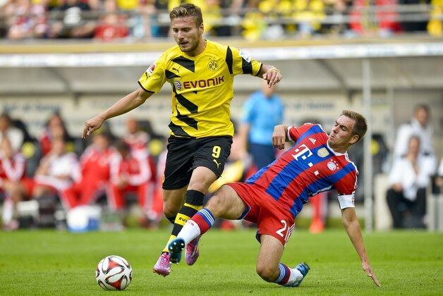 Dortmund's Ciro Immobile, left,  and Munich's Philipp Lahm vie for the ball with during the German soccer Super Cup match between Borussia Dortmund and Bayern Munich in Dortmund, Germany, Wednesday, Aug. 13, 2014. (AP Photo/Sascha Schuermann)