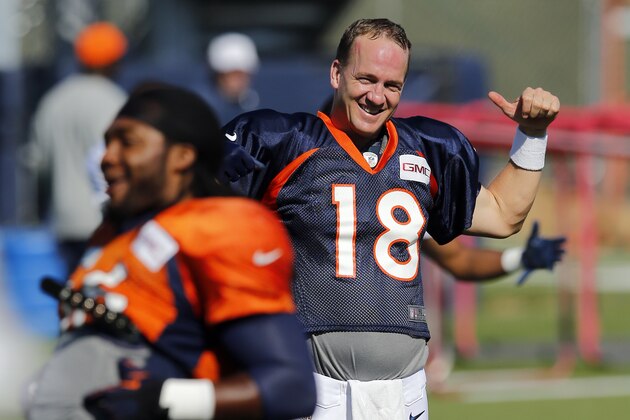 Denver Broncos' Peyton Manning smiles while stretching during NFL football training camp on Tuesday, Aug 12, 2014, in Englewood, Colo. (AP Photo/Jack Dempsey)