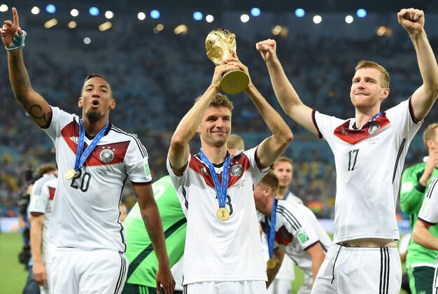 July 13, 2014; Rio de Janeiro, BRAZIL; Germany defender Jerome Boateng (20), midfielder Thomas Muller (13), and defender Per Mertesacker (17) celebrate after winning the championship match of the 2014 World Cup against the Argentina at Maracana Stadium.  Germany won 1-0. Mandatory Credit: Tim Groothuis/Witters Sport via USA TODAY Sports