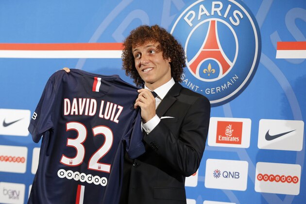 Brazil's David Luiz  holds his soccer shirt, as he poses for photographers following a press conference, in Paris, Thursday, Aug. 7, 2014. Defender Luiz believes the only way to get over his World Cup disappointment is to be back on the pitch as quickly as possible. French champion Paris Saint-Germain signed Luiz on a five-year deal that was announced before his lackluster performances in Brazil's last two games at the World Cup last month. (AP Photo/Jacques Brinon)