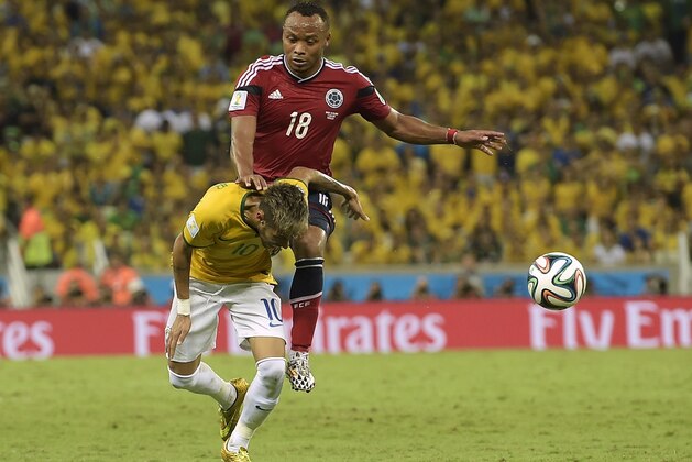 Brazil's Neymar is fouled by Colombia's Juan Zuniga during the World Cup quarterfinal soccer match between Brazil and Colombia at the Arena Castelao in Fortaleza, Brazil, Friday, July 4, 2014. (AP Photo/Manu Fernandez)