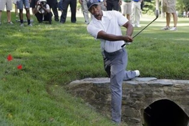Tiger Woods hits out of the rough on the 11th hole during the second round of the Quicken Loans National PGA golf tournament, Friday, June 27, 2014, in Bethesda, Md. Woods finished the round at 7 over par for the tournament, and missed the cut. (AP Photo/Patrick Semansky) Tiger Woods hits out of the rough on the 11th hole during the second round of the Quicken Loans National PGA golf tournament, Friday, June 27, 2014, in Bethesda, Md. Woods finished the round at 7 over par for the tournament, and missed the cut. (AP Photo/Patrick Semansky)