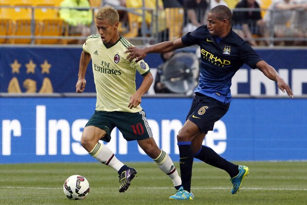 Milan forward Keisuke Honda (10)  dribbles the ball past Manchester City midfielder Fernando (6) during the first half of a soccer match in the first round of the Guinness International Champions Cup at Heinz Field on Sunday, July 27, 2014, in Pittsburgh. (AP Photo/Gene J. Puskar)