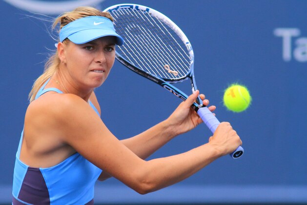 Maria Sharapova, of Russia, returns a volley to Madison Keys at the Western & Southern Open tennis tournament, Tuesday, Aug. 12, 2014, in Mason, Ohio. (AP Photo/Tom Uhlman)