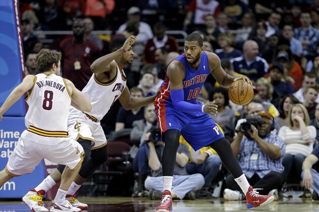 Detroit Pistons' Greg Monroe (10) backs in against Cleveland Cavaliers' Tristan Thompson and Matthew Dellavedova (8), in an NBA basketball game Wednesday, April 9, 2014, in Cleveland. (AP Photo/Mark Duncan)