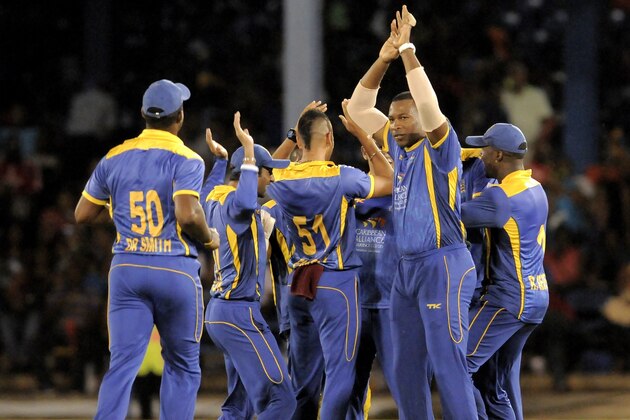 PORT OF SPAIN, TRINIDAD AND TOBAGO - AUGUST 23:  Kieron Pollard (R) of Barbados Tridents celebrates Jamaica Tallawahs Chris Gayle out during the Second Semi Final of the Caribbean Premier League between Barbados Tridents v Jamaica Tallawahs at Queens Park Oval on August 23, 2013 in Port of Spain, Trinidad and Tobago. (Photo by Randy Brooks/LatinContent/Getty Images)