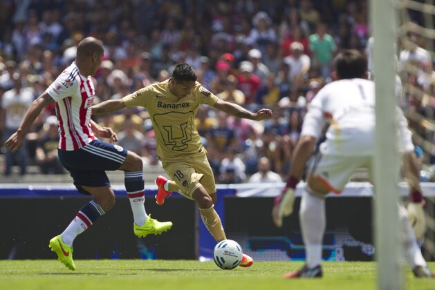 Pumas´ Ismael Sosa, right, competes for the ball with Chivas' Carlos Salcido during a Mexican soccer league match in Mexico City, Saturday, July 26, 2014. (AP Photo/Christian Palma)