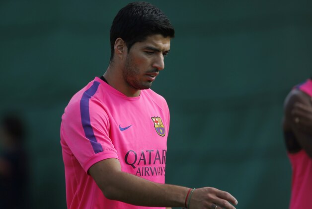 Luis Suarez of Uruguay walks during a training session at the Sports Center FC Barcelona Joan Gamper in San Joan Despi in Barcelona, Spain, Friday, Aug. 15, 2014. Suarez trained with his Barcelona teammates on Friday after his ban for biting an opponent at the World Cup was softened but not shortened.  The Court of Arbitration for Sport ruled Thursday that the Uruguay forward, who recently left Liverpool for Barcelona, deserves his four-month ban from playing official matches for both his club and his country. (AP Photo/Emilio Morenatti )