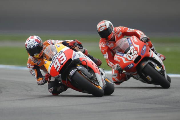 Marc Marquez, of Spain, leads Andrea Dovizioso, of Italy, through a turn during qualifying for the Indianapolis Moto GP motorcycle race at the Indianapolis Motor Speedway in Indianapolis, Saturday, Aug. 9, 2014. Marquez won the pole, Dovizioso was second. (AP Photo/Michael Conroy)