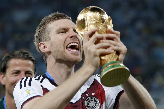 Germany's Per Mertesacker celebrates with the trophy after the World Cup final soccer match between Germany and Argentina at the Maracana Stadium in Rio de Janeiro, Brazil, Sunday, July 13, 2014. Germany won the match 1-0. (AP Photo/Matthias Schrader)