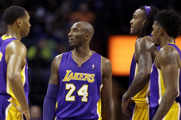Los Angeles Lakers' Kobe Bryant (24) huddles during a timeout with teammates Pau Gasol (16), Wesley Johnson (11), Jordan Hill (27) and Nick Young (0) during the second half of an NBA basketball game in Charlotte, N.C., Saturday, Dec. 14, 2013. The Lakers won 88-85. (AP Photo/Bob Leverone)