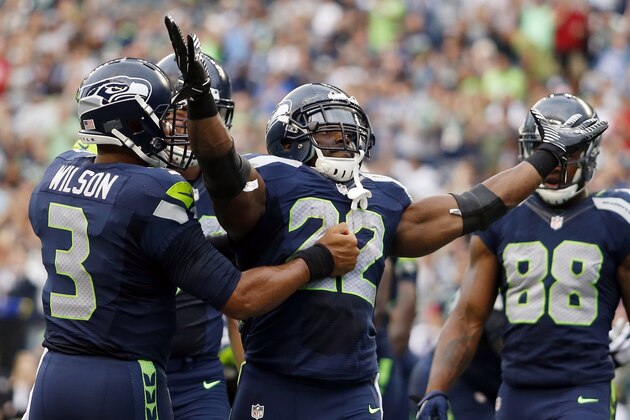 Seattle Seahawks quarterback Russell Wilson, left, celebrates with running back Robert Turbin (22) after Turbin scored a touchdown against the San Diego Chargers in the first half of a preseason NFL football game, Friday, Aug. 15, 2014, in Seattle. (AP Photo/John Froschauer)