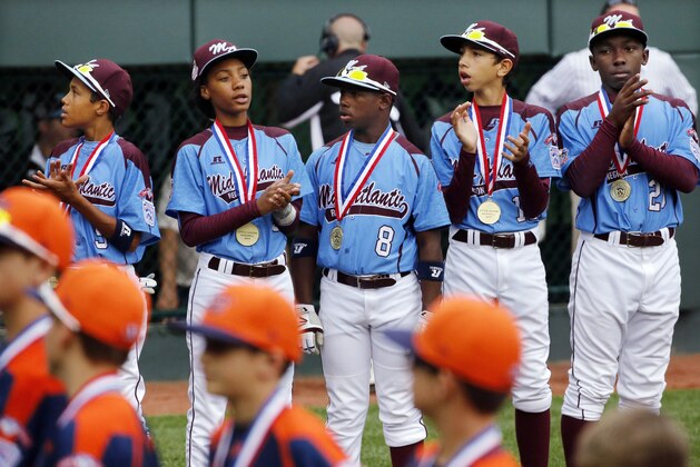 Philadelphia pitcher Mo'ne Davis, second from left, stands with her teammates before they played Nashville during a baseball game in U.S. pool play at the Little League World Series tournament in South Williamsport, Pa., Friday, Aug. 15, 2014. Philadelphia won 4-0. (AP Photo/Gene J. Puskar)