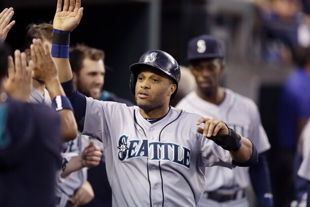 Seattle Mariners' Robinson Cano is congratulated in the dugout after scoring during the fifth inning of a baseball game against the Detroit Tigers, Friday, Aug. 15, 2014, in Detroit. (AP Photo/Carlos Osorio)
