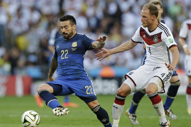 Argentina's Ezequiel Lavezzi, left, is challenged by Germany's Benedikt Hoewedes during the World Cup final soccer match between Germany and Argentina at the Maracana Stadium in Rio de Janeiro, Brazil, Sunday, July 13, 2014. (AP Photo/Victor R. Caivano)