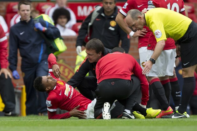 Manchester United's Jesse Lingard reacts after being injured during his team's English Premier League soccer match against Swansea City at Old Trafford Stadium, Manchester, England, Saturday Aug. 16, 2014. (AP Photo/Jon Super)