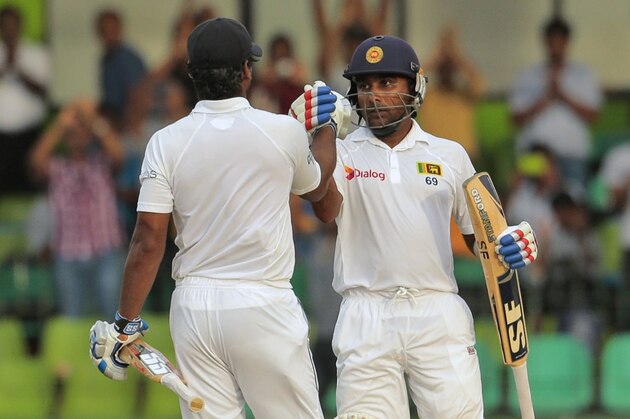 Sri Lankan batsmen Mahela Jayawardene, right, and Kumar Sangakkara cheer each other during the third day of the second test cricket match between Sri Lanka and Pakistan in Colombo, Sri Lanka, Saturday, Aug. 16, 2014. (AP Photo/Eranga Jayawardena)