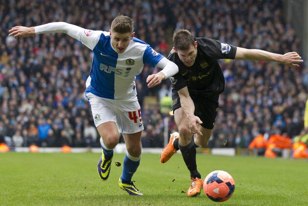 Manchester City's James Milner, right, fights for the ball against Blackburn Rovers' Tom Cairney during their English FA Cup third round soccer match at Ewood Park Stadium, Blackburn, England, Saturday, Jan. 4, 2014. (AP Photo/Jon Super)