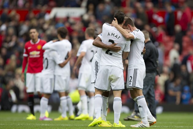 Swansea City's players celebrate after their 2-1 win over Manchester United in their English Premier League soccer match at Old Trafford Stadium, Manchester, England, Saturday Aug. 16, 2014. (AP Photo/Jon Super)
