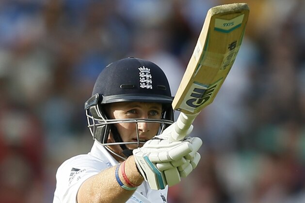 England's Joe Root celebrates getting 50 runs not out during the second day of the fifth test cricket match against India at Oval cricket ground in London, Saturday, Aug. 16, 2014. (AP Photo/Alastair Grant)