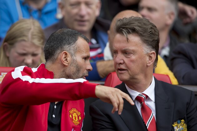 Manchester United's manager Louis van Gaal, right, takes his seat alongside assistant coach Ryan Giggs before the team's English Premier League soccer match against Swansea City at Old Trafford Stadium, Manchester, England, Saturday Aug. 16, 2014. (AP Photo/Jon Super)