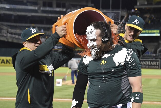August 4, 2014; Oakland, CA, USA; Oakland Athletics first baseman Stephen Vogt (21, left) and first baseman Nate Freiman (35, right) dump Gatorade on catcher Derek Norris (36, center) after Norris hit the game-winning RBI-single during the 10th inning against the Tampa Bay Rays at O.co Coliseum. The Athletics defeated the Rays 3-2. Mandatory Credit: Kyle Terada-USA TODAY Sports