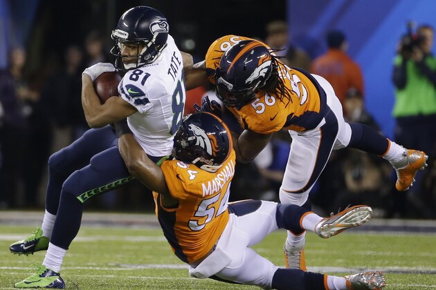 Seattle Seahawks' Golden Tate (81) is tackled by Denver Broncos' Brandon Marshall (54) and Nate Irving (56), during the first half of the NFL Super Bowl XLVIII football game Sunday, Feb. 2, 2014, in East Rutherford, N.J. (AP Photo/Matt Slocum)