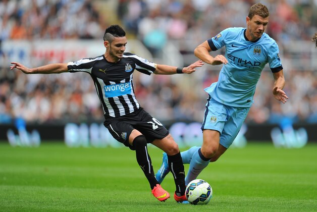 NEWCASTLE UPON TYNE, ENGLAND - AUGUST 17:  Newcastle player Remy Cabella (l) challenges Edin Dzeko of Man City during the Barclays Premier League match between Newcastle United and Manchester City at St James' Park on August 17, 2014 in Newcastle upon Tyne, England.  (Photo by Stu Forster/Getty Images)