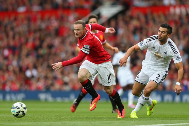 MANCHESTER, ENGLAND - AUGUST 16:  Wayne Rooney of Manchester United competes with Jordi Amat of Swansea City during the Barclays Premier League match between Manchester United and Swansea City at Old Trafford on August 16, 2014 in Manchester, England.  (Photo by Alex Livesey/Getty Images)