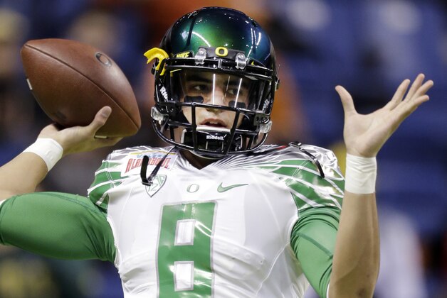 FILE-This Dec. 30, 2013 file photo shows Oregon's Marcus Mariota warms up for the Valero Alamo Bowl NCAA college football game against Texas in San Antonio. All eyes will be on Mariota when the Ducks take the field this season. The junior quarterback could have bolted for the NFL this spring but he decided to stay with the Ducks, who were ranked as high as No. 2 last season before two losses took them out of contention for the national championship. (AP Photo/Eric Gay,File)