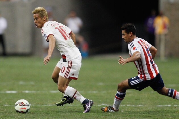 Milan midfielder Keisuken Honda (10) avoids Guadalajara midfielder Patricio Araujo (5) in the first half of a soccer match at NRG Stadium Wednesday, Aug. 6, 2014 in Houston. (AP Photo/Bob Levey)