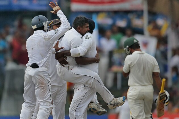 Sri Lankan players lift their bowler Rangana Herath as they celebrate the wicket of Pakistan's Asad Shafiq during the fourth day of the second test cricket match  in Colombo, Sri Lanka, Sunday, Aug.17, 2014. (AP Photo/Eranga Jayawardena)