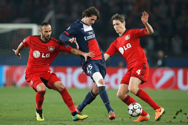 PARIS, FRANCE - MARCH 12:  Adrien Rabiot of Paris Saint-Germain (C) battles with Omer Toprak (L) and Philipp Wollscheid of Bayer Leverkusen (R) during the UEFA Champions League Round of 16 second leg match between Paris Saint-Germain FC and Bayer Leverkusen at Parc des Princes on March 12, 2014 in Paris, France.  (Photo by Dean Mouhtaropoulos/Getty Images)