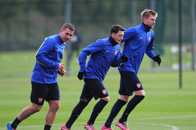 ST ALBANS, ENGLAND - NOVEMBER 25:  Lukas Podolski, Mesut Ozil and Per Mertesacker of Arsenal warm up during a training session at London Colney on November 25, 2013 in St Albans, England.  (Photo by Shaun Botterill/Getty Images)