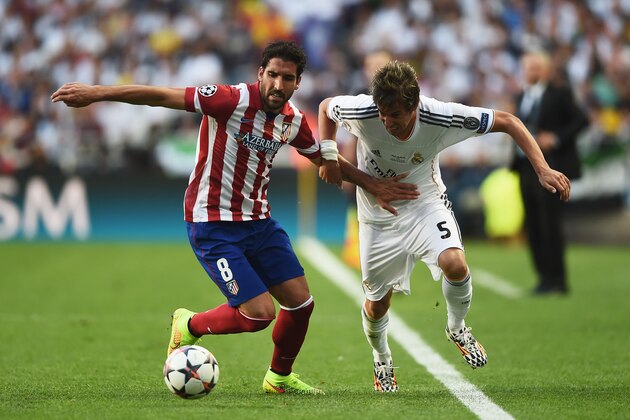 LISBON, PORTUGAL - MAY 24:  Raul Garcia of Club Atletico de Madrid battles with Fabio Coentrao of Real Madrid during the UEFA Champions League Final between Real Madrid and Atletico de Madrid at Estadio da Luz on May 24, 2014 in Lisbon, Portugal.  (Photo by Laurence Griffiths/Getty Images)