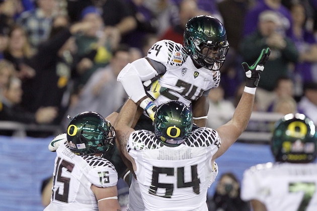 Oregon's Kenjon Barner, top, celebrates with teammates Colt Lyerla, left, and Tyler Johnstone, right, against Kansas State during the Fiesta Bowl NCAA college football game Thursday, Jan. 3, 2013, in Glendale, Ariz. (AP Photo/Paul Connors)