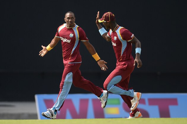 ANTIGUA, ANTIGUA AND BARBUDA - MARCH 05:  Dwayne Bravo of the West Indies celebrates with Darren Sammy after dismissing Ben Stokes of England during the 3rd One Day International between the West Indies and England at Sir Viv Richards Cricket Ground on March 5, 2014 in Antigua, Antigua and Barbuda.  (Photo by Gareth Copley/Getty Images)