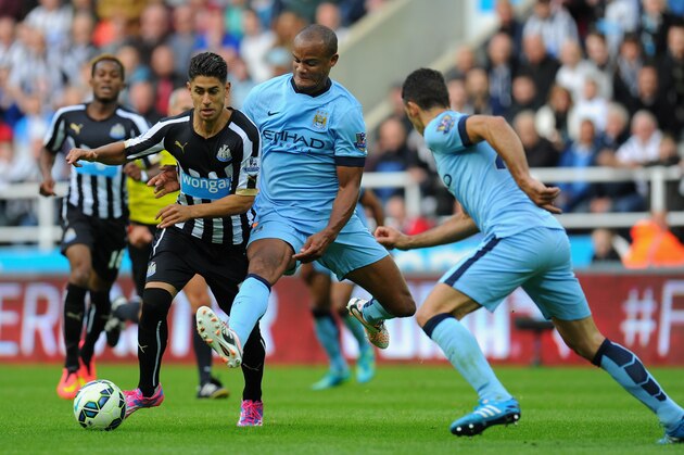 NEWCASTLE UPON TYNE, ENGLAND - AUGUST 17:  Vincent Kompany of Man City (c) challenges Ayoze Perez of Newcastle during the Barclays Premier League match between Newcastle United and Manchester City at St James' Park on August 17, 2014 in Newcastle upon Tyne, England.  (Photo by Stu Forster/Getty Images)