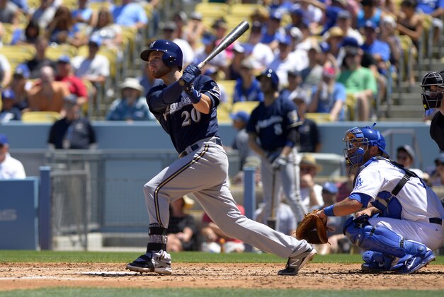 Milwaukee Brewers' Jonathan Lucroy, left, hits a three run double as Los Angeles Dodgers catcher Drew Butera looks on during the second inning of a baseball game, Sunday, Aug. 17, 2014, in Los Angeles. (AP Photo/Mark J. Terrill)