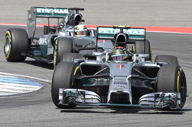 Mercedes driver Nico Rosberg, front, of Germany followed by Mercedes Formula One driver Lewis Hamilton of Great Britain steers his car to clock the fastest time during the qualification at the German Formula One Grand Prix in Hockenheim, Germany, Saturday, July 19, 2014. The German Grand Prix will be held on Sunday, July 20, 2014. (AP Photo/Jens Meyer)