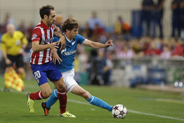 Atletico Madrid's Juanfran, left, duels for the ball with Zenit St. Petersburg Cristian Ansaldi during a Group G Champions League soccer match at the Vicente Calderon stadium in in Madrid, Spain, Wednesday, Sept. 18, 2013 . (AP Photo/Daniel Ochoa de Olza)