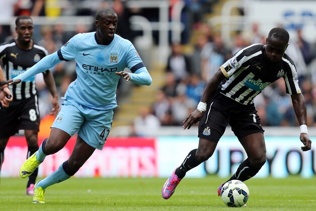 Newcastle United's Moussa Sissoko, right, vies for the ball with Manchester City's Yaya Toure, left, during their English Premier League soccer match at St James' Park, Newcastle, England, Sunday, Aug. 17, 2014. (AP Photo/Scott Heppell)