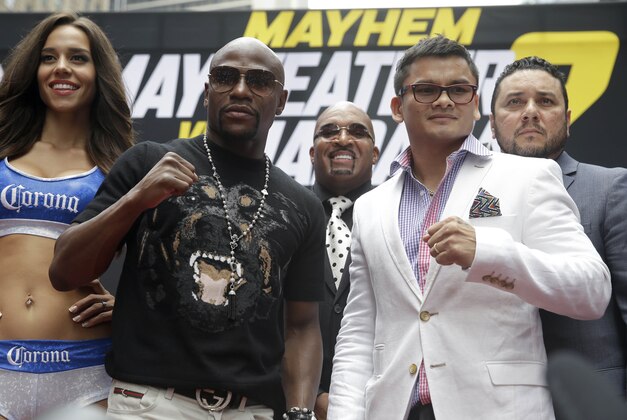 Floyd Mayweather, second from left, poses for a picture with Marcos Maidana, second from right, during the outdoor portion of a news conference in Times Square, New York, Monday, July 14, 2014. Mayweather will fight Maidana for the second time in Las Vegas, Nevada on Sept. 13, 2014. (AP Photo/Seth Wenig)