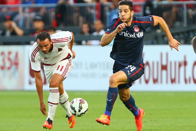 TORONTO, ON - JULY 24: Giampaolo Pazzini #11 of AC Milan chases the ball against Kostas Manolas #24 of Olympiacos FC during International Champions Cup 2014 action at BMO Field July 24, 2014 in Toronto, Ontario, Canada.  (Photo by Abelimages/Getty Images)