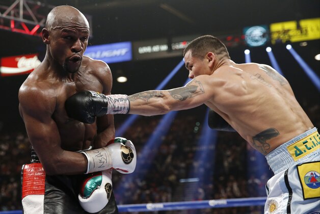 Marcos Maidana, right, from Argentina, throws a left to the body of Floyd Mayweather Jr. in their WBC-WBA welterweight title boxing fight Saturday, May 3, 2014, in Las Vegas. (AP Photo/Eric Jamison)